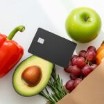 Best credit cards for groceries in the USA showing a credit card placed on fresh produce and a grocery bag representing cashback rewards on supermarket spending for American households in 2026